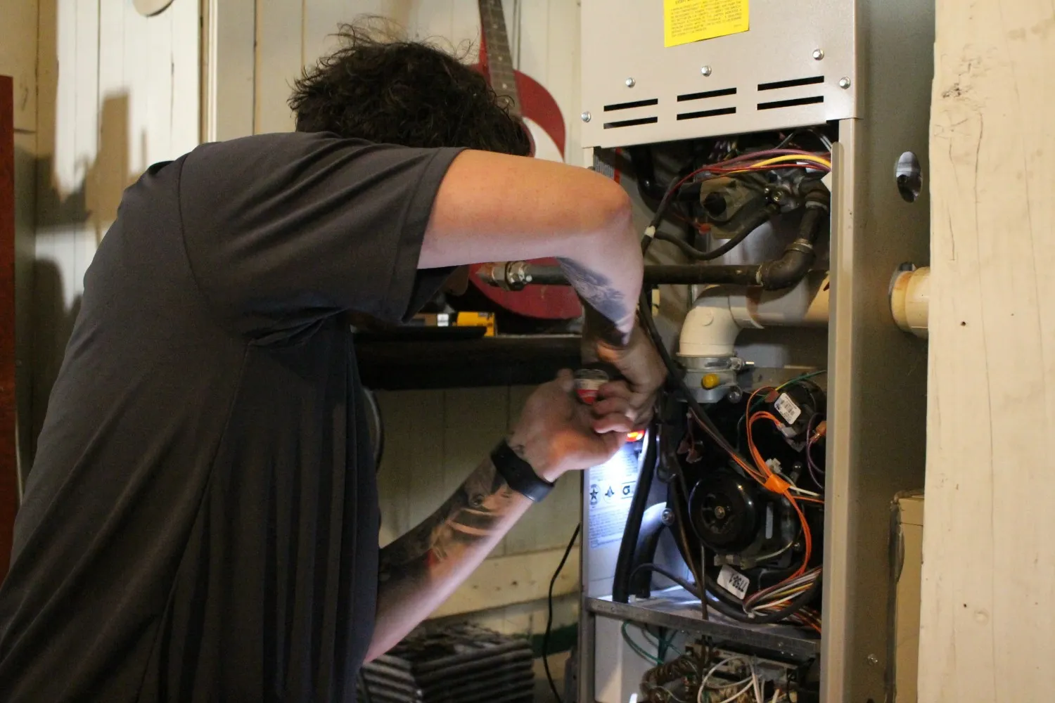 Technician inspecting an open residential furnace